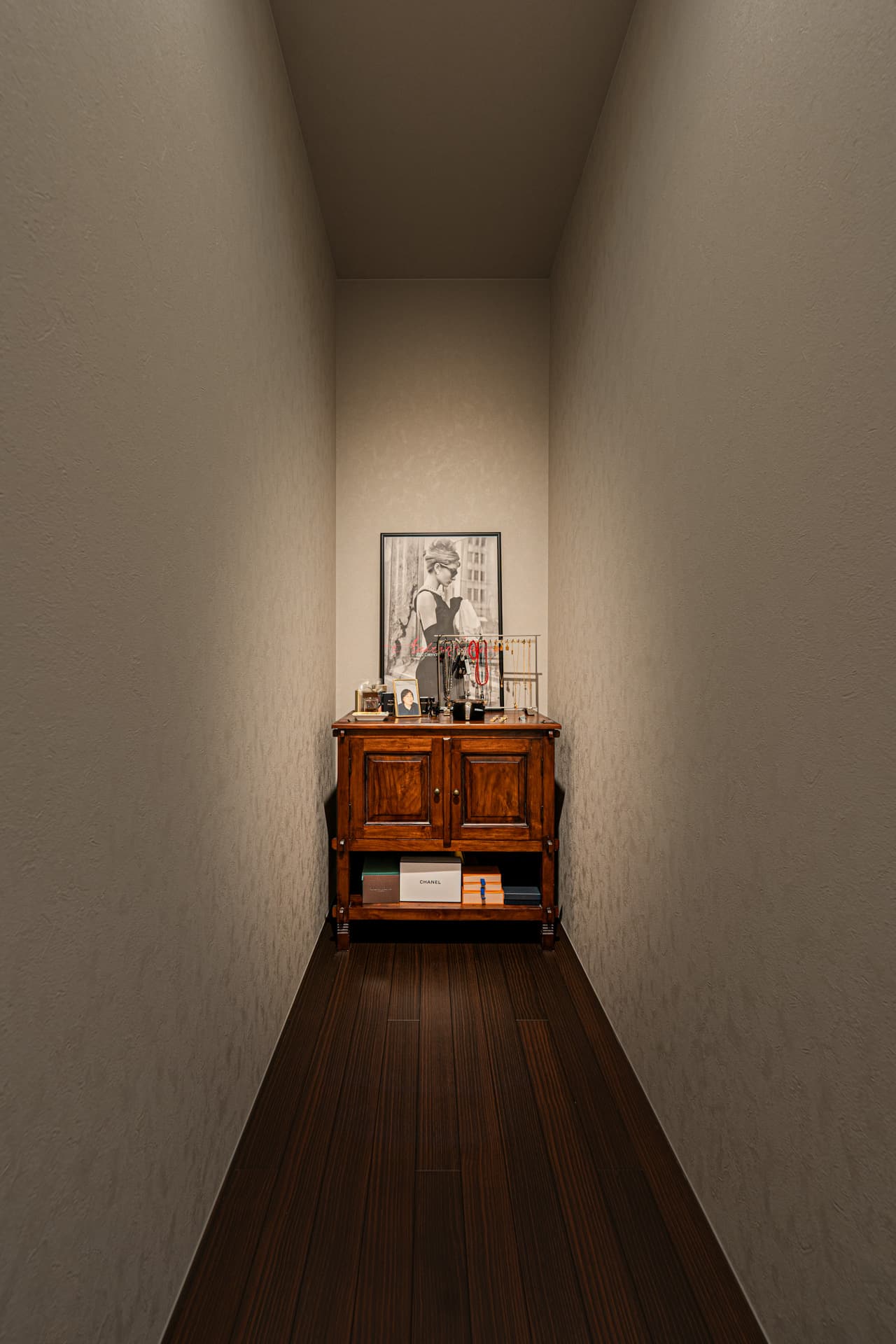 廊下の先に写真やアクセサリー、香水などが並ぶ棚